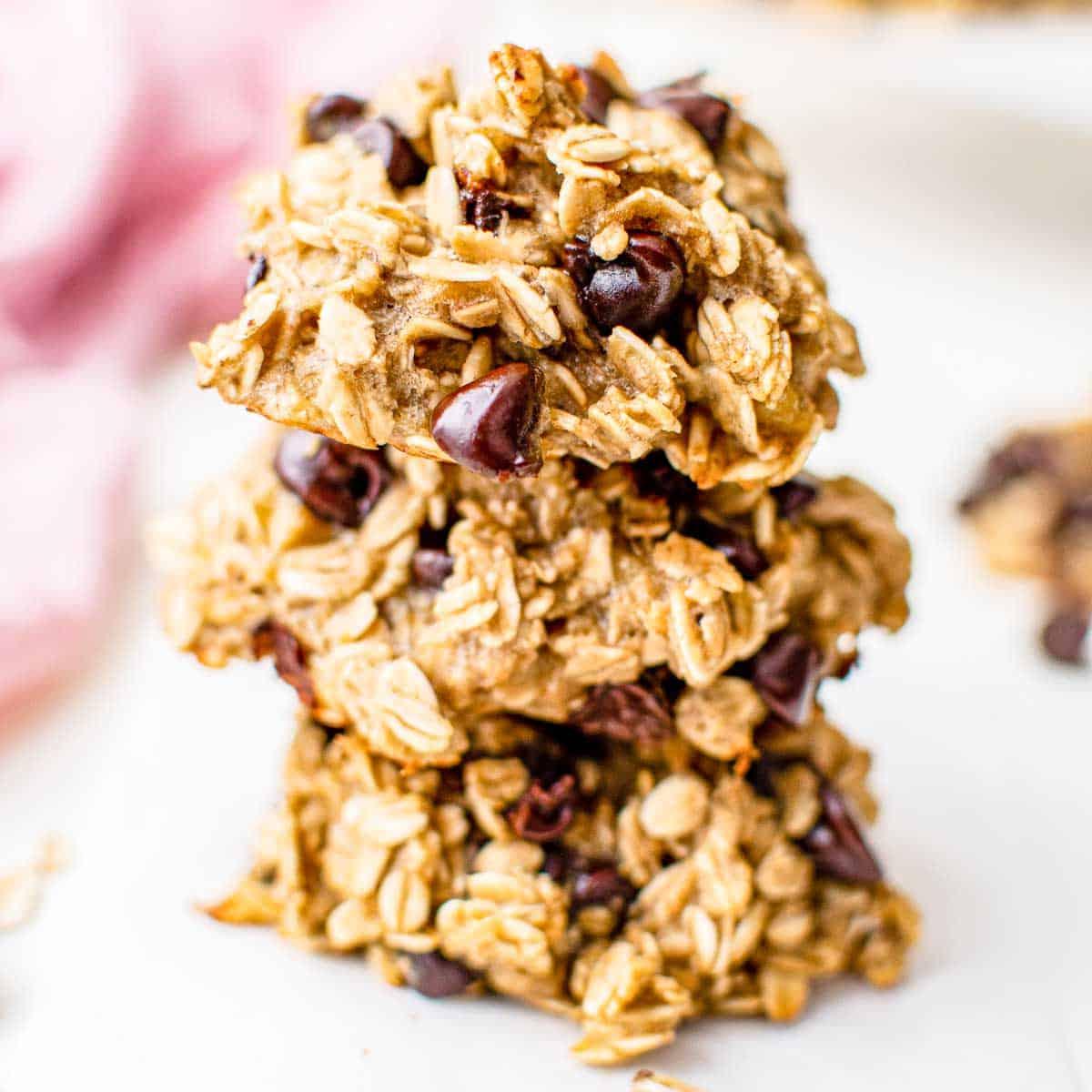Gesunde Haferflockenkekse – Einfaches Frühstück oder Snack! 2 Ein Stapel von drei Haferflockenkeksen mit Schokostückchen auf hellem Hintergrund.