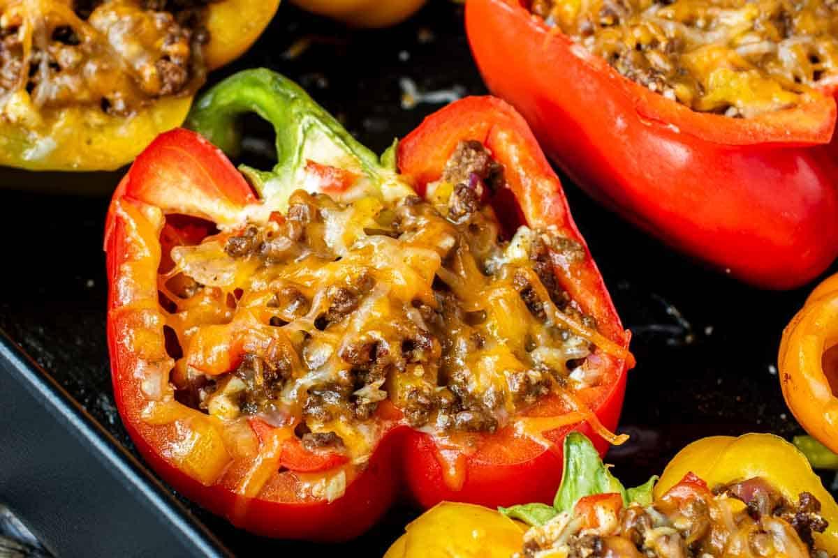 Leichte Mexikanische Gefüllte Paprika mit Reis 7 Ofenfrische rote Paprikahälften, gefüllt mit Hackfleisch-Reis-Mischung und überbacken mit geschmolzenem Käse auf einem Backblech.