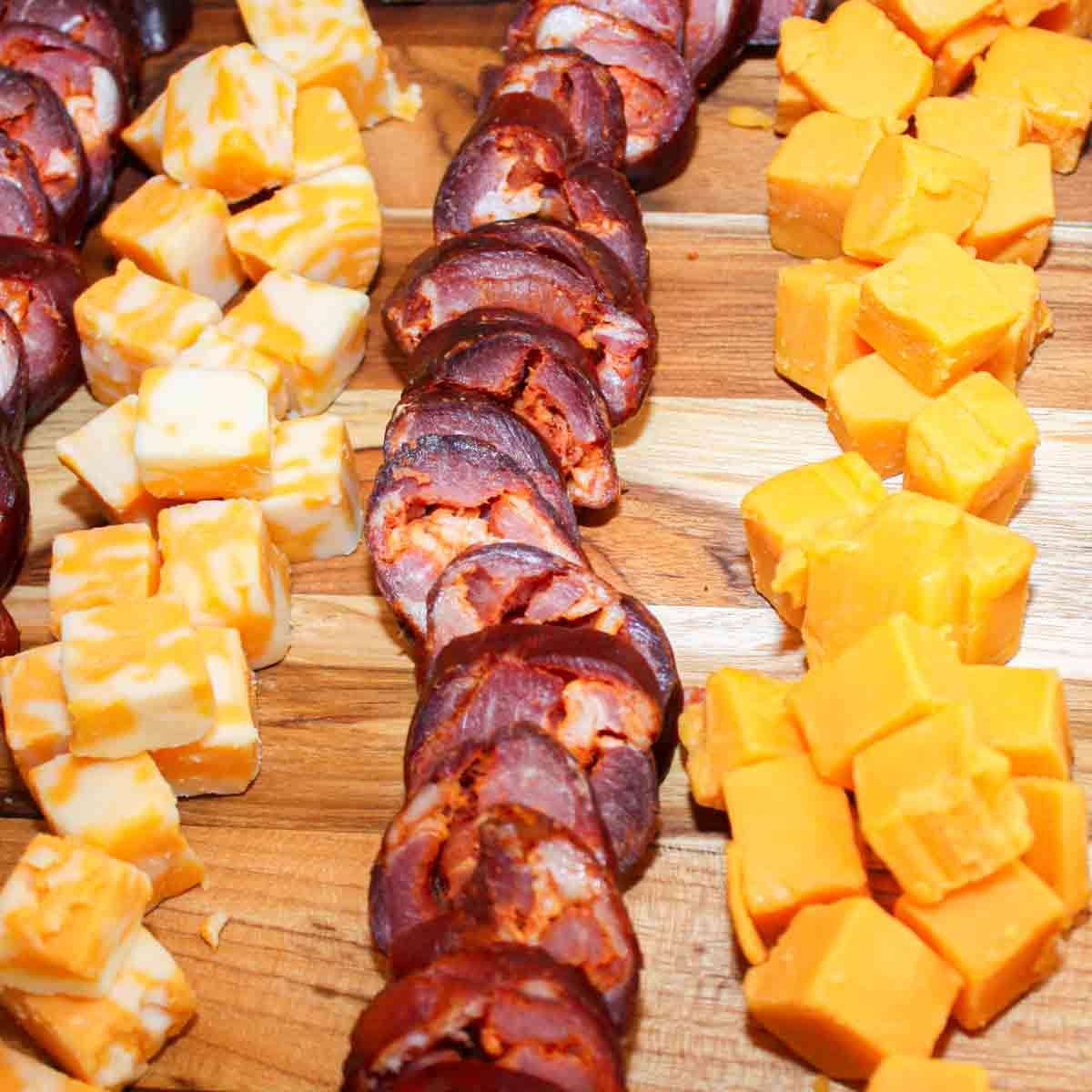 Hausgemachtes Chouriço herstellen: Eine traditionelle portugiesische Wurst 14 Ein Tablett mit Käse und portugiesischer Wurst auf einem Holzbrett.