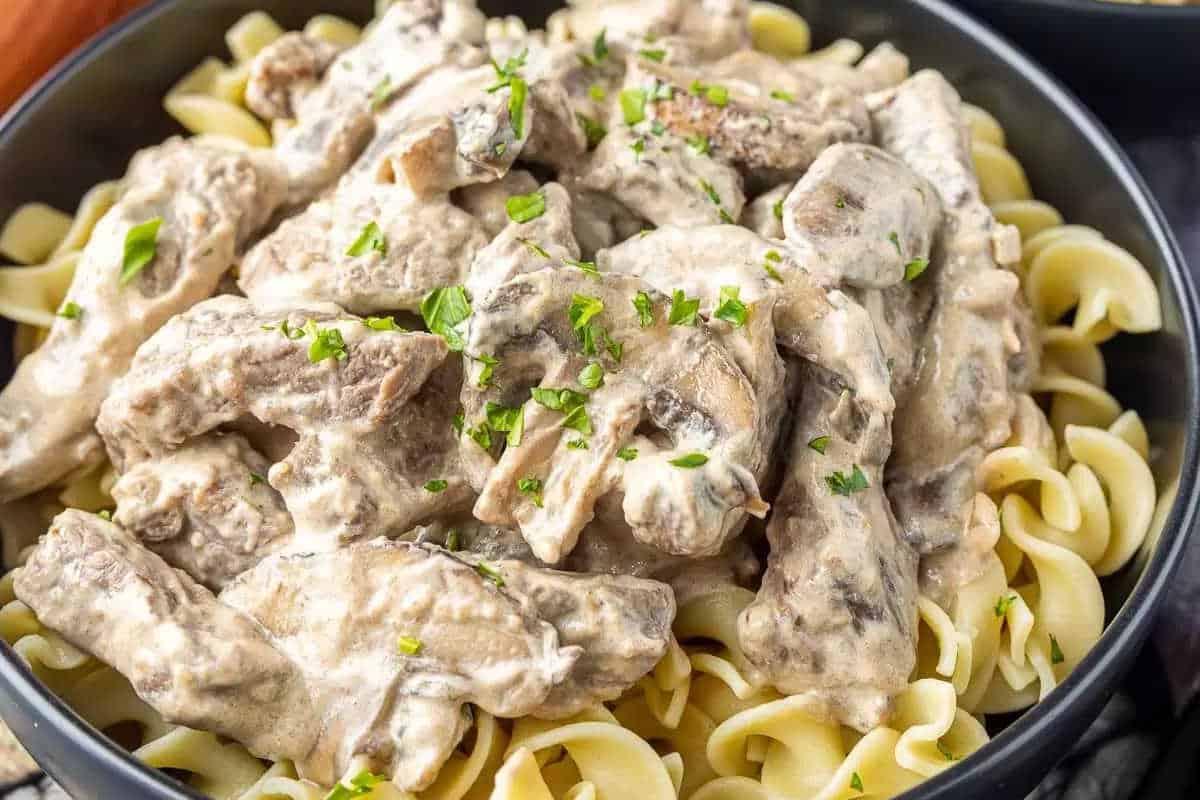 33 einfache und günstige Gerichte (die Ihre Familie auch wirklich essen möchte) 17 Eine Schale mit Eiernudeln, belegt mit cremigem Beef Stroganoff und garniert mit gehackter Petersilie.