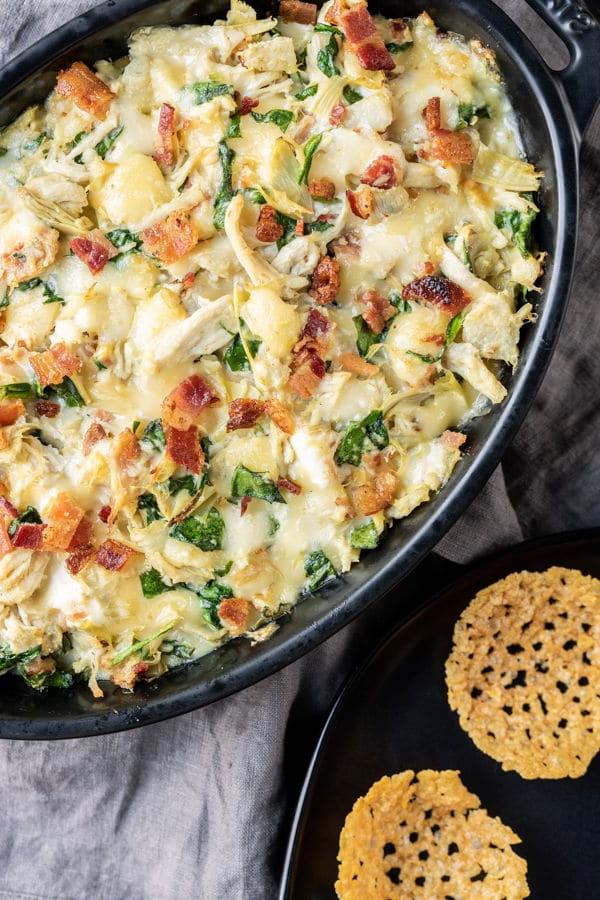 Keto Hähnchen-Artischocken-Dip 3 Nahaufnahme des gebackenen Hähnchen-Artischocken-Dips in einer Auflaufform, dampfend und bereit zum Servieren