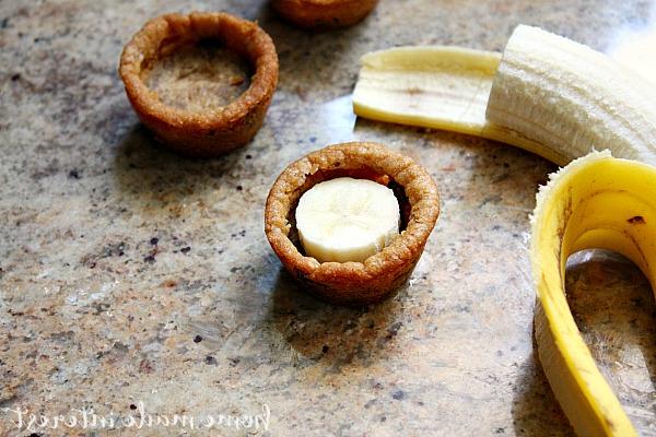 Bananensplit-Keksbecher 3 Diese einfachen Bananensplit Cookie Cups sind perfekt für Sommerpartys... oder einfach ein lustiges Dessert für Ihre Familie! Leckerer Keksteig in Tassen gebacken und gefüllt mit Schokolade, Bananenscheiben, Schlagsahne und natürlich einer Kirsche obendrauf. Wer braucht einen einfachen Eisbecher, wenn er einen Bananen-Eisbecher-Keksbecher haben kann!