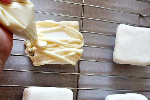 Wählen Sie die richtigen Zutaten für Ihre Mumien-Marshmallows: große Marshmallows, essbare Augen und Mandel-Kuvertüre oder Candy Melts für die perfekte gruselige Hülle.