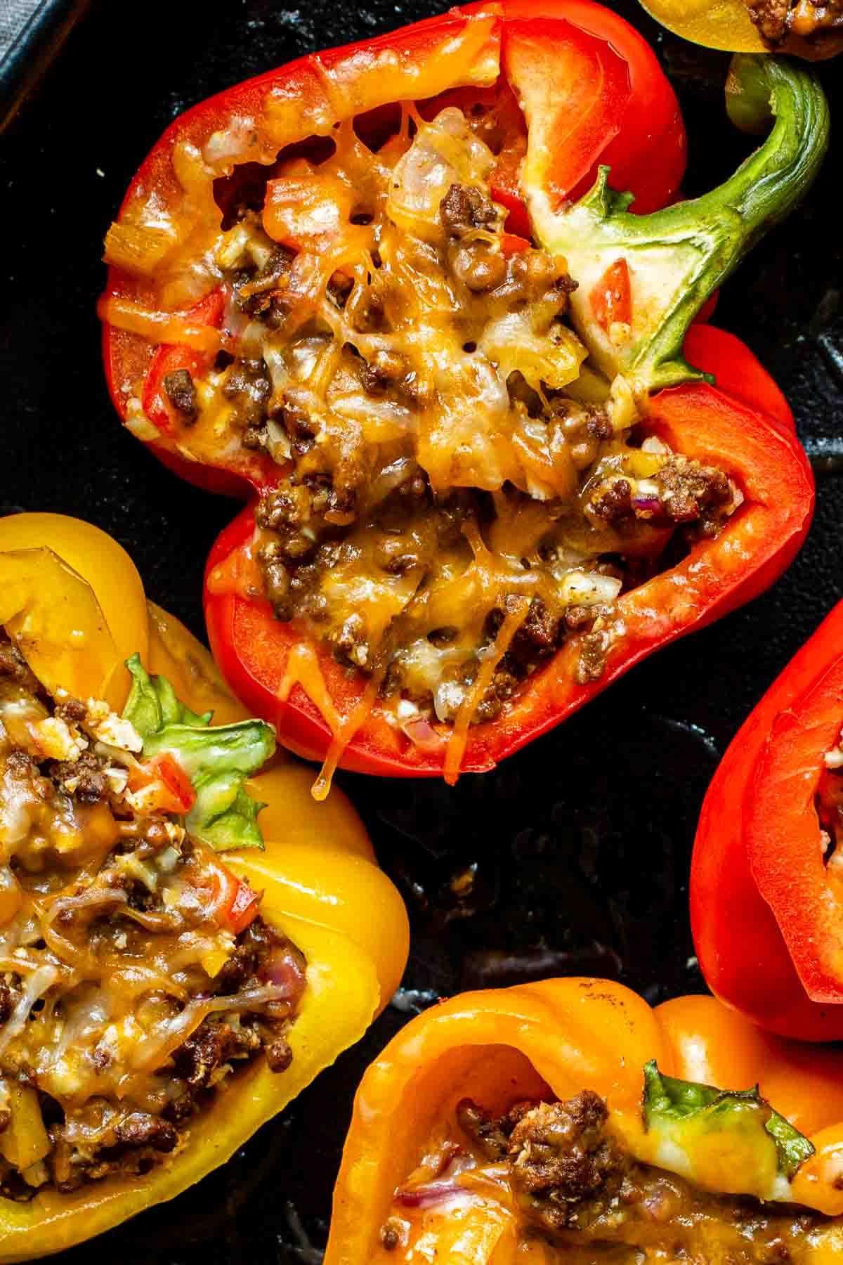 Leichte Mexikanische Gefüllte Paprika mit Reis 9 Nahaufnahme von roten und gelben gefüllten Paprika, gebacken mit geschmolzenem Käse und Füllung.