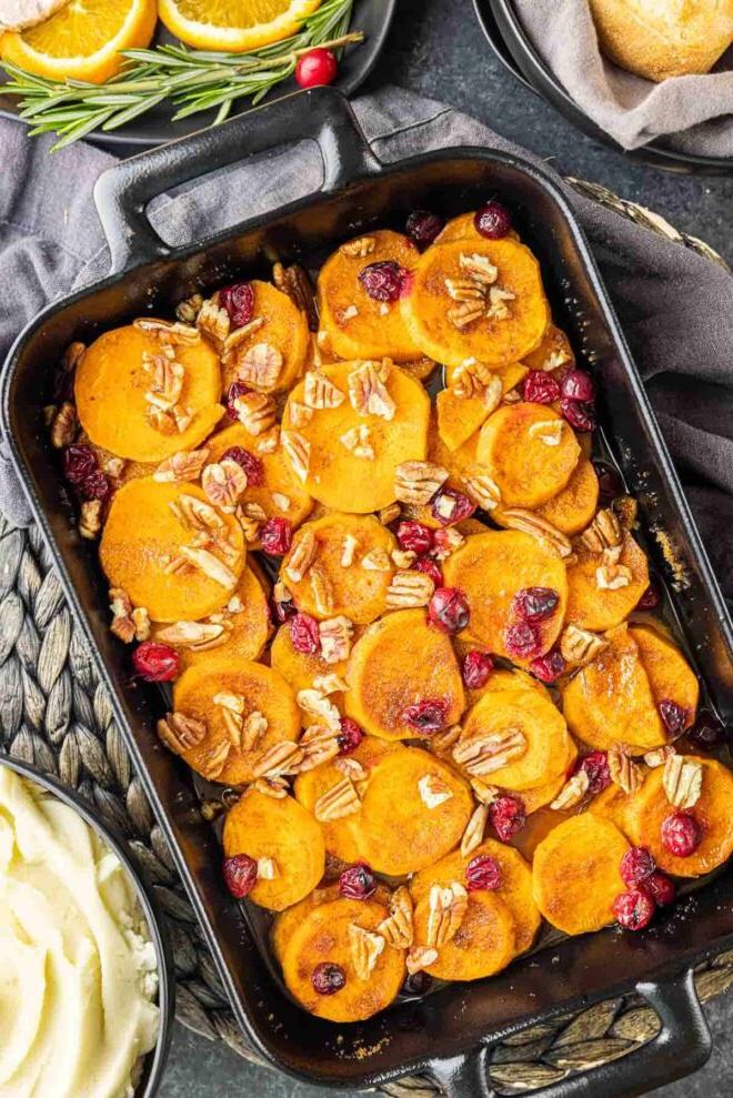 Cranberry-Süßkartoffel-Auflauf 12 Festlicher Süßkartoffel-Preiselbeer-Auflauf in schwarzer Auflaufform mit gehackten Pekannüssen