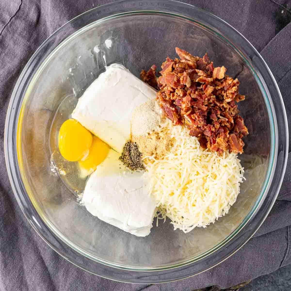 Spinat-Blätterteig-Vorspeise 4 Eine Schüssel mit Zutaten für eine Speck-, Ei- und Käsefüllung für Spinat-Blätterteig-Häppchen