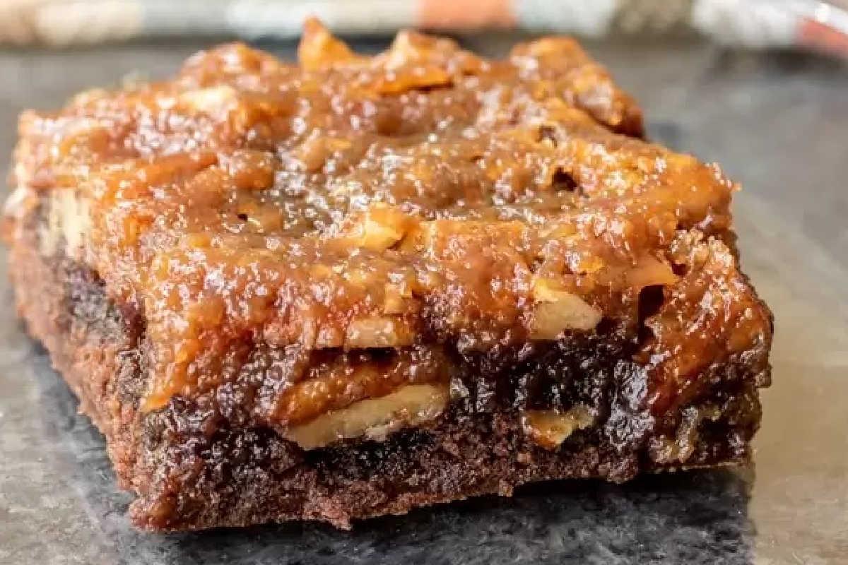Unwiderstehliche Desserts mit Pekannusskuchenfüllung 6 Nahaufnahme eines Karamell-Apfel-Brownie-Riegels mit sichtbaren Apfelschichten und einem reichhaltigen, glänzenden Topping.