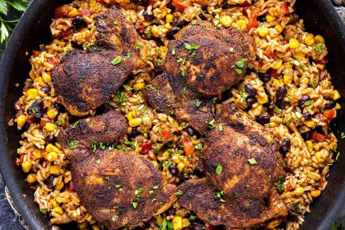 **Schnelle und einfache Hähnchengerichte für vielbeschäftigte Familien** 6 Eine Pfanne gefüllt mit würzigem Jambalaya-Reis, gemischt mit verschiedenen Gemüsesorten, gekrönt mit fünf gewürzten, gegrillten Hühnchenschenkeln, garniert mit Kräutern.