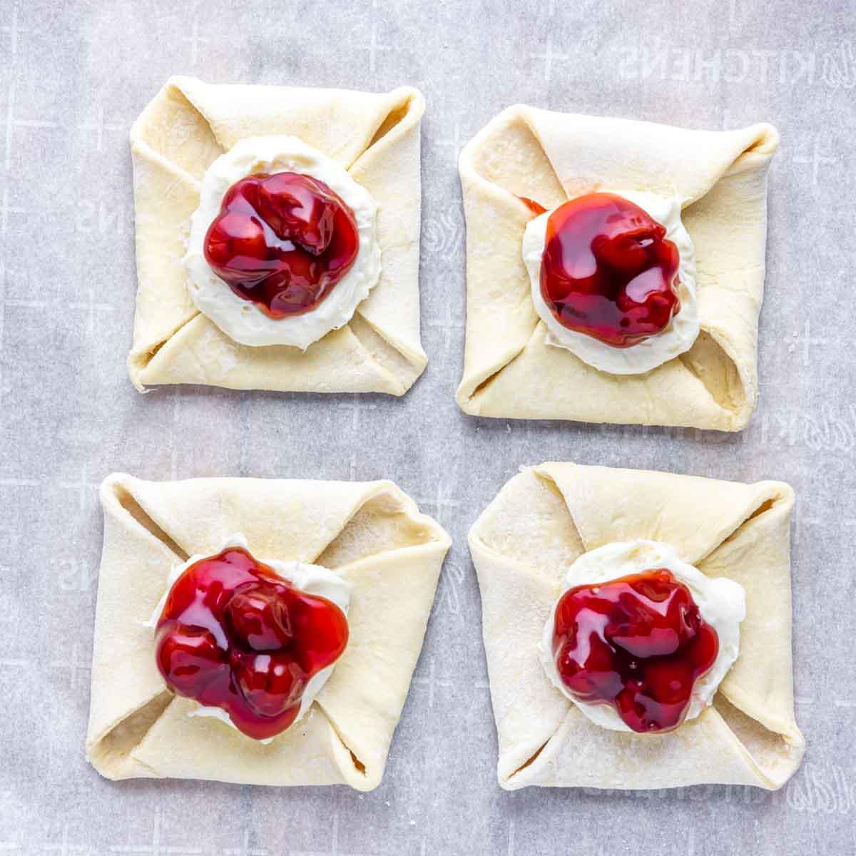 Einfacher Kirschplunder mit Frischkäse 6 Zusammengestelltes Kirsch-Dänisch vor dem Backen
