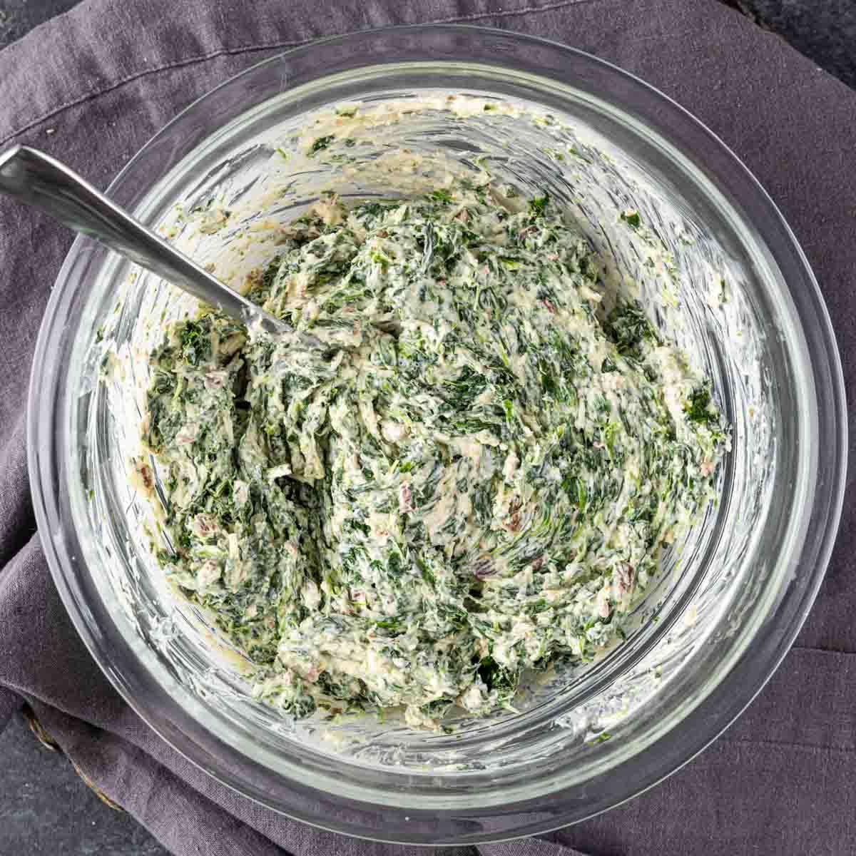 Spinat-Blätterteig-Vorspeise 5 Spinat-Füllung in einer Schüssel mit einem Löffel.