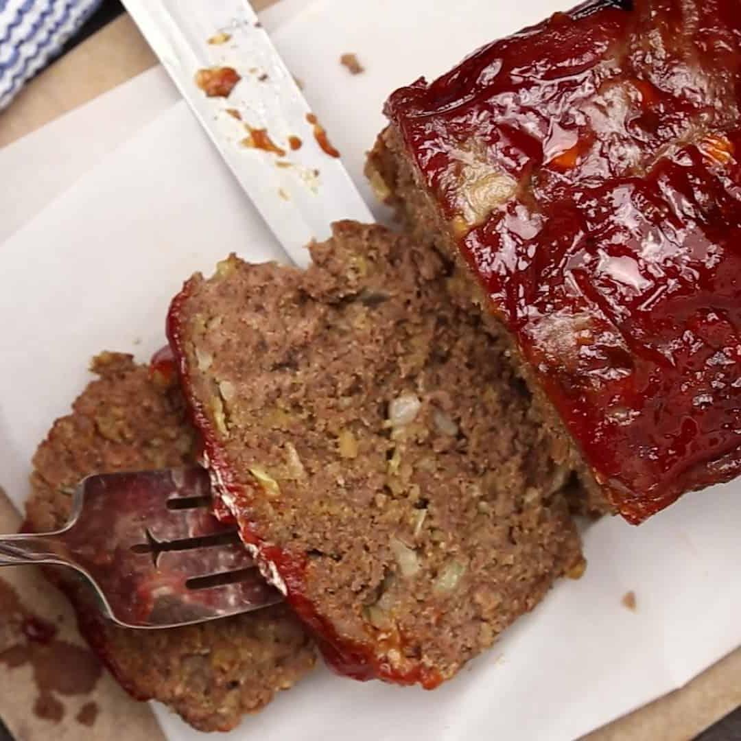 Keto Hackbraten – Low-Carb-Soulfood 8 Ein frisch angeschnittenes Stück ketogener Hackbraten auf einem Teller, bereit zum Genuss, mit einer Gabel daneben.