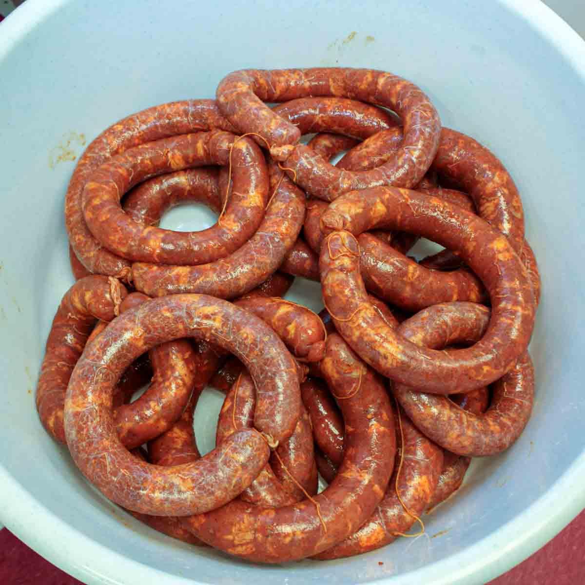 Hausgemachtes Chouriço herstellen: Eine traditionelle portugiesische Wurst 9 Eine Schale mit Würsten in einer weißen Schale.