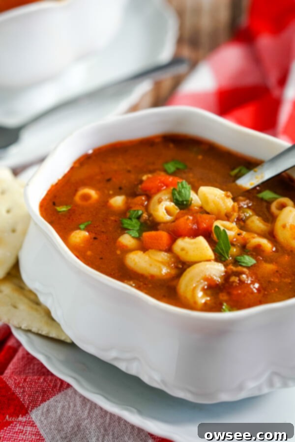 Sloppy Joe Stuffed Garlic Bread 4 A white soup tureen full of hamburger macaroni soup with a soup spoon in the bowl and crackers to the side, a perfect hearty meal.