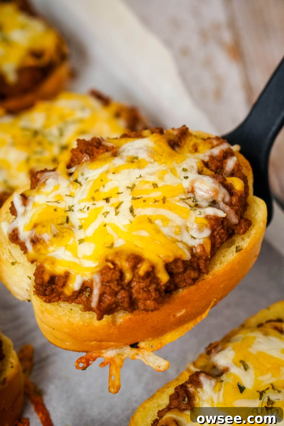 Sloppy Joe Stuffed Garlic Bread 10 Hero shot of delicious Garlic Bread Sloppy Joes on a wooden board.