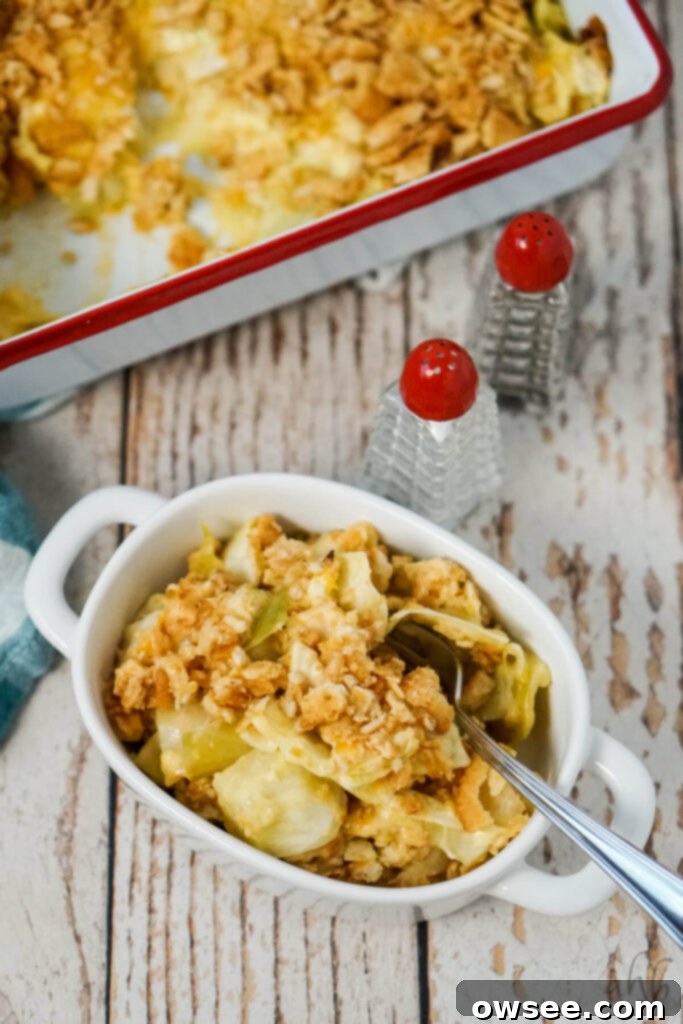 Creamy Cabbage Bake 3 A serving of Scalloped Cabbage Casserole in a white bowl next to salt and pepper shakers.