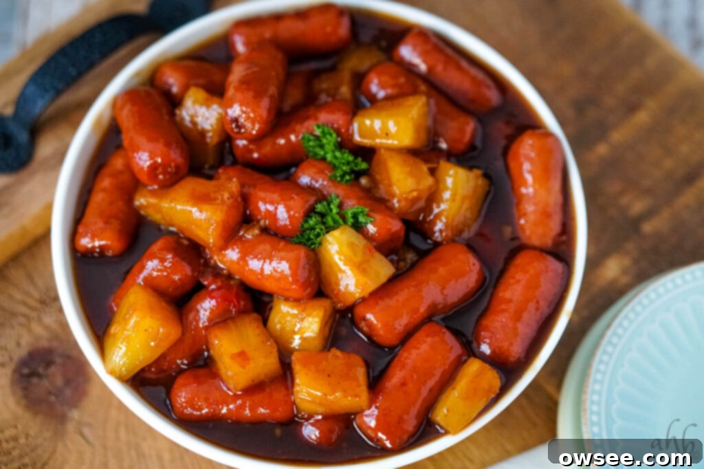 Hawaiian Little Smokies 3 A bowl of Hawaiian Lit'l Smokies with pineapple and sauce on a serving tray, ready for a party.