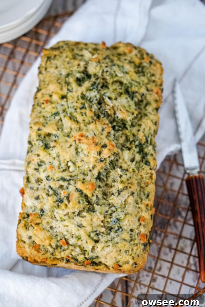 Savory Spinach Feta Beer Bread 3 A loaf of freshly baked spinach and feta beer bread turned out of the loaf pan and cooling on a wire rack.