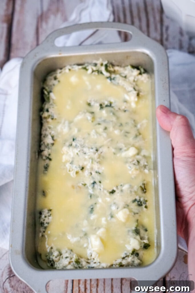Savory Spinach Feta Beer Bread 9 The mixture is added to a bread pan, and melted butter is poured on top.