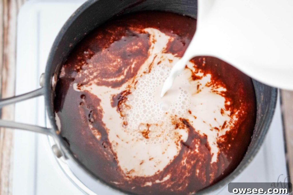 Zesty Cocoa Bliss 9 Milk being poured into the saucepan, mixing with the dark chocolate syrup base.
