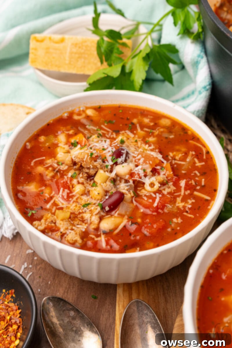 Savory Sausage Pasta Fagioli: An Effortless Comfort 10 A beautifully presented bowl of Easy Pasta Fagioli soup, topped with generous shredded Parmesan cheese and fresh parsley, ready to be savored.