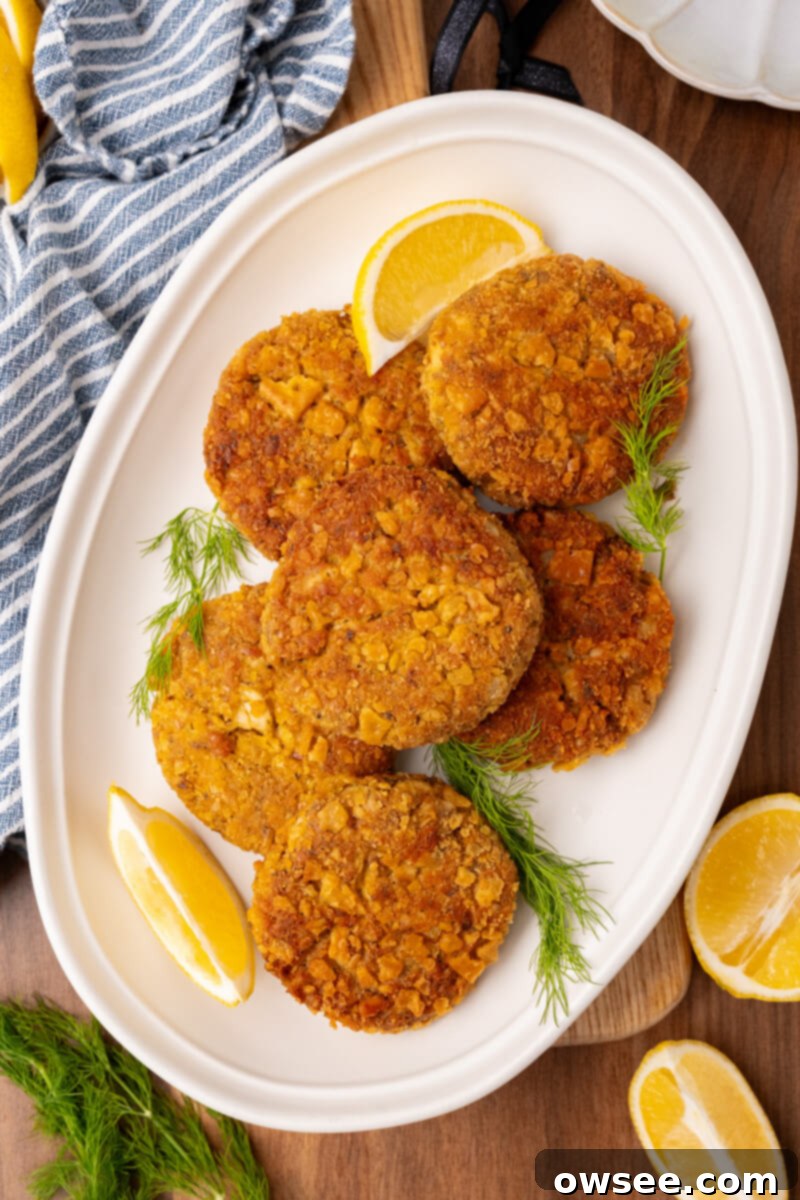 Grandma's Homestyle Salmon Patties 10 Golden brown salmon patties on a plate with lemon and dill.