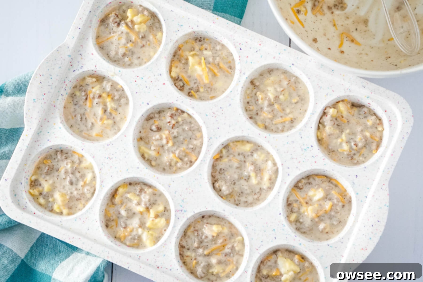 All-in-One Breakfast Muffins 8 The savory pancake muffin mixture is carefully scooped into a greased muffin tin, filling each cup about two-thirds full.