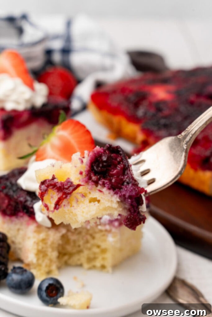 Caramelized Berry Flip Cake 4 A bite of Berry Upside Down Cake is taken out of the serving and held aloft on a fork.