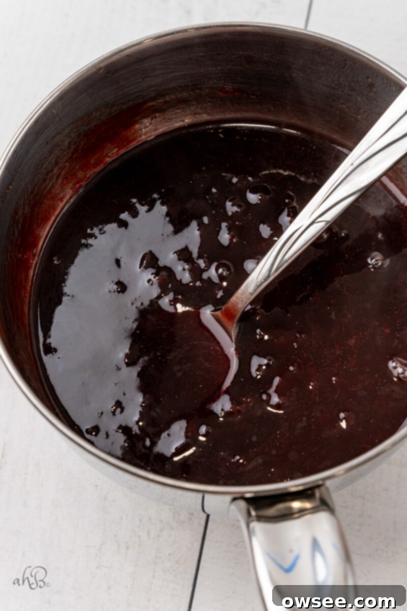 Making the Bourbon Glaze The bourbon glaze is stirred in a pot, showing its rich, glossy texture.