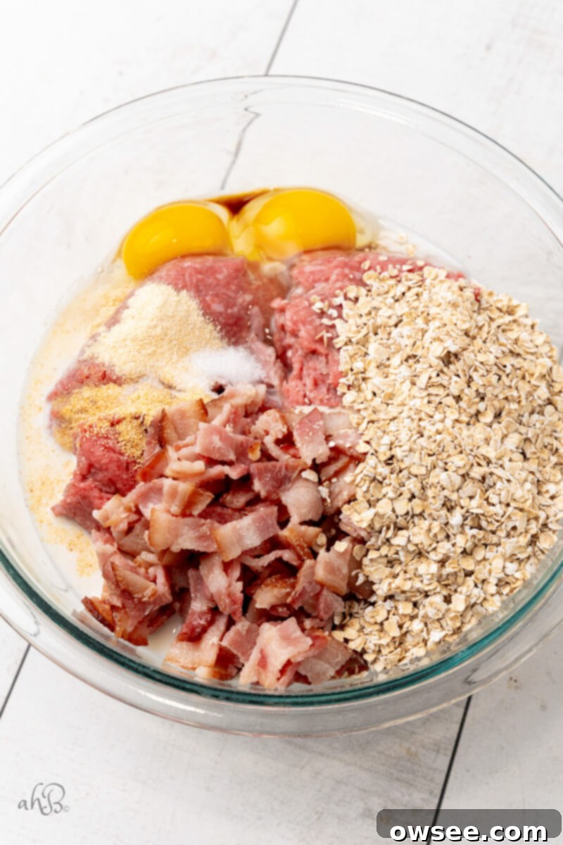 Ultimate Bourbon Bacon Meatloaf 2 All the meatloaf ingredients are added to a large glass bowl, ready for mixing.