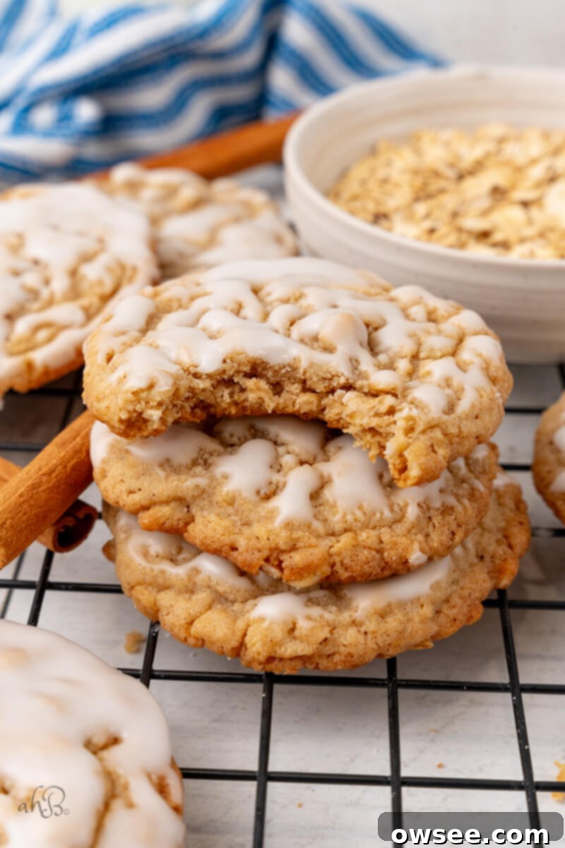 Iced Oatmeal Cookies-16 3 cookies are stacked on top of each other and the top one has a bite taken out of it.
