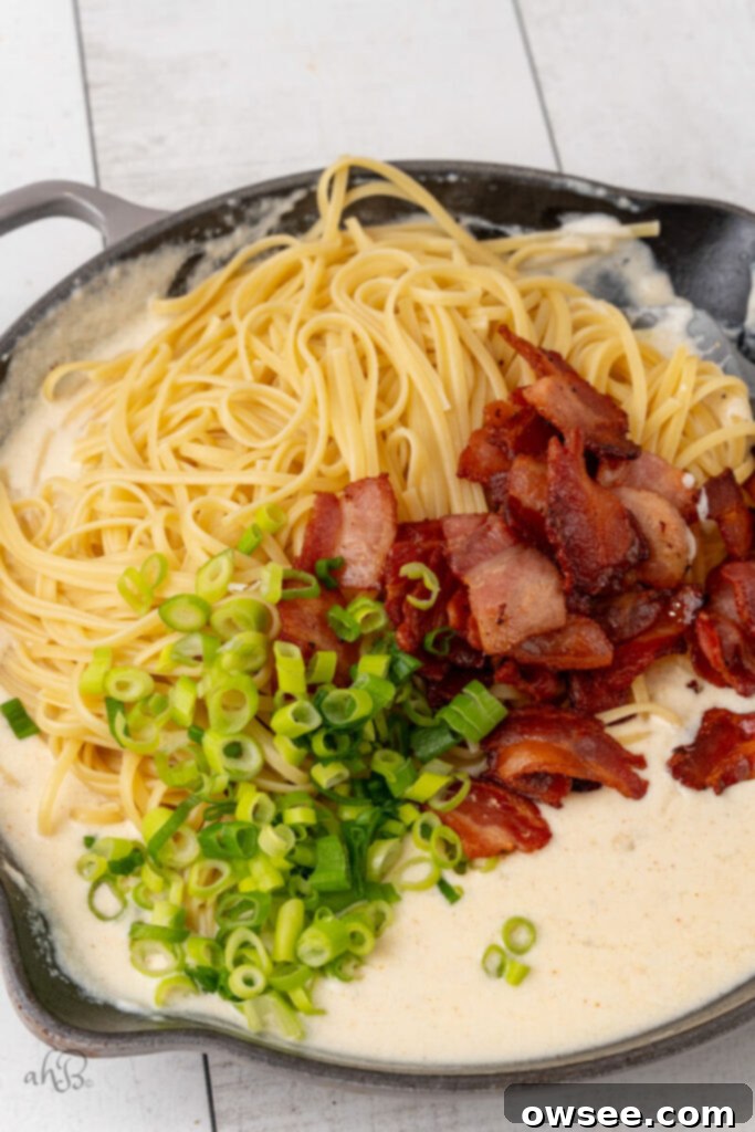 Creamy Tang Pasta 10 The pasta, bacon pieces, and green onions are added to the skillet.