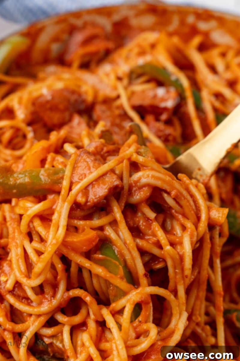 Bayou Sausage Spaghetti 2 Cajun Sausage Spaghetti is stirred with a wooden spoon.