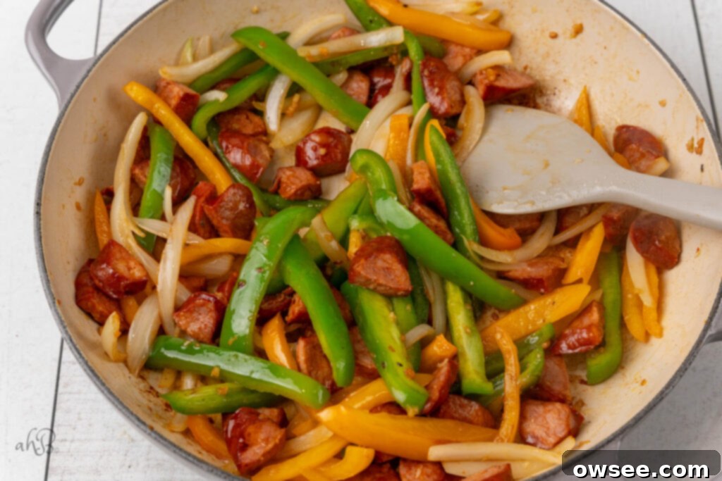 Bayou Sausage Spaghetti 7 The onions and peppers are added to the pot and stirred.
