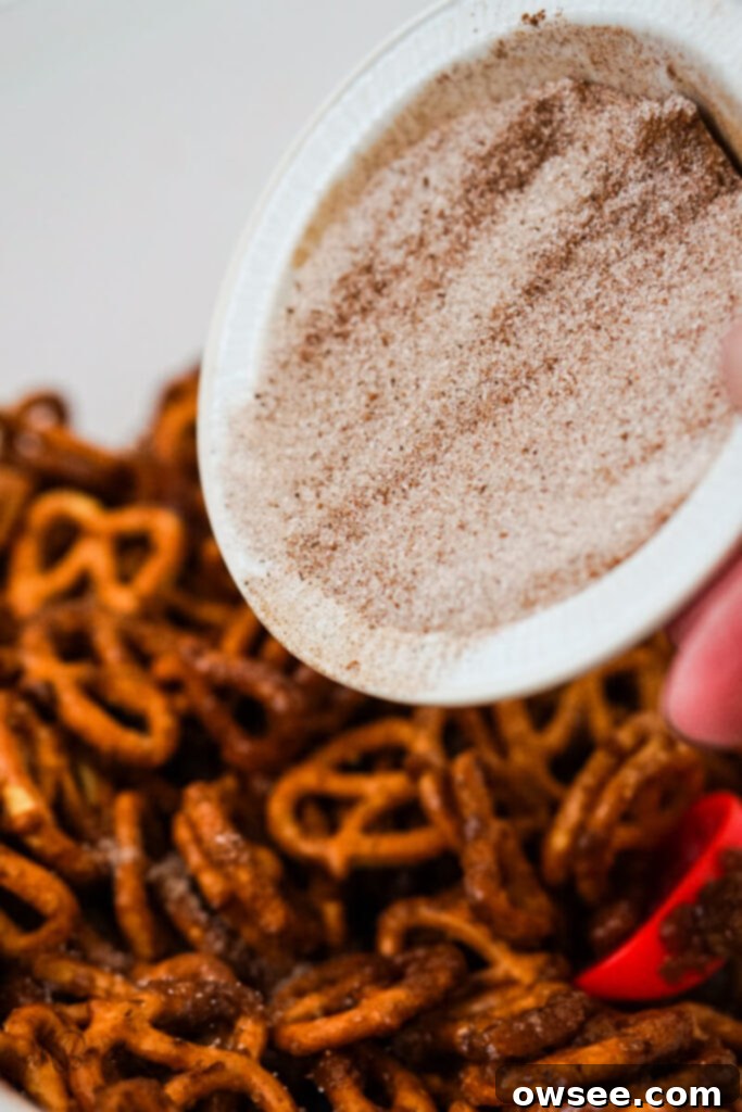 The sugar spice mixture is poured over the pretzels. 