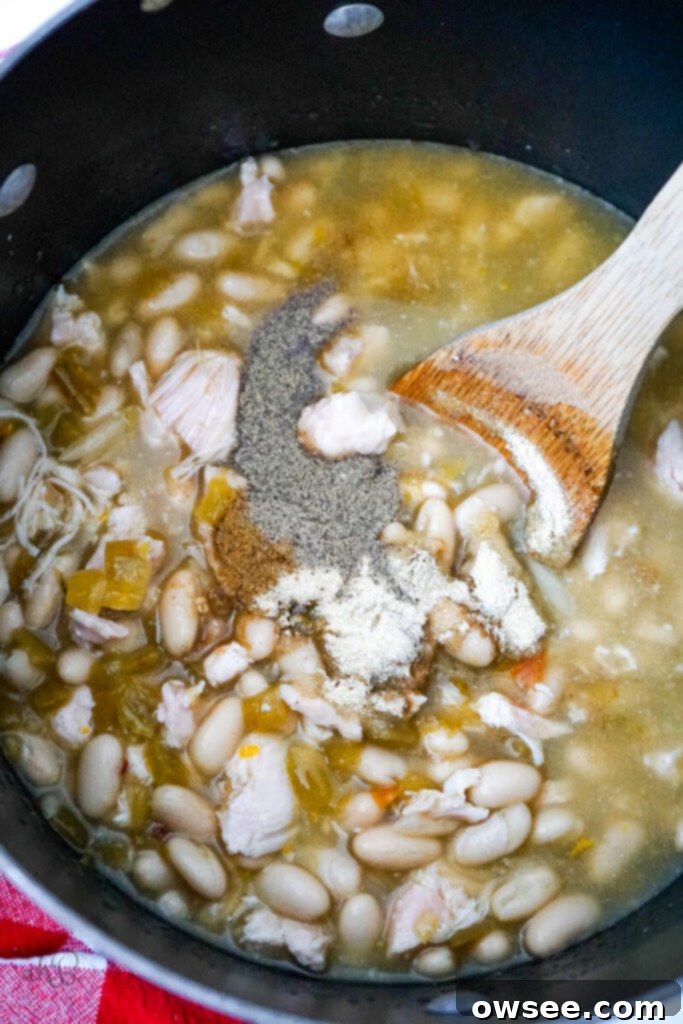 No-Fuss 7 Can Chicken Chili 6 All the prepared ingredients, including beans, chicken, broth, and seasonings, are combined in a large stock pot, ready to simmer and meld their flavors.