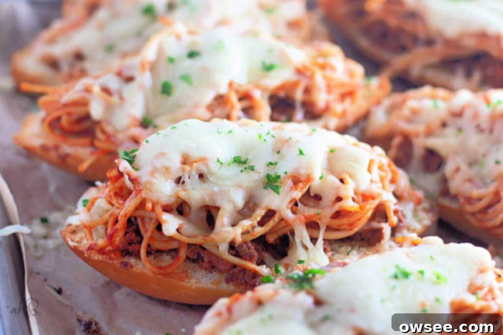 Quick Spaghetti Bread 3 A close up image of a slice of garlic bread topped with spaghetti and meat sauce.