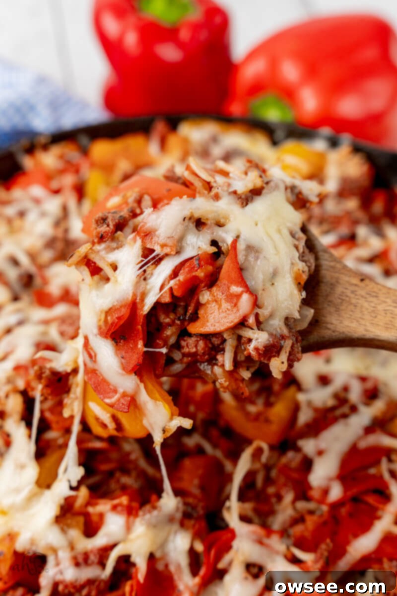 One-Pan Pizza Pepper Skillet 3 A wooden spoon scoops the Pizza Unstuffed Peppers Skillet.