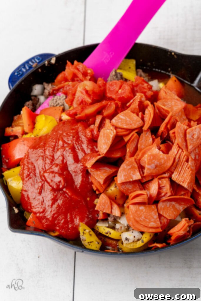 One-Pan Pizza Pepper Skillet 7 The pepperoni and tomato sauce are added to the skillet.