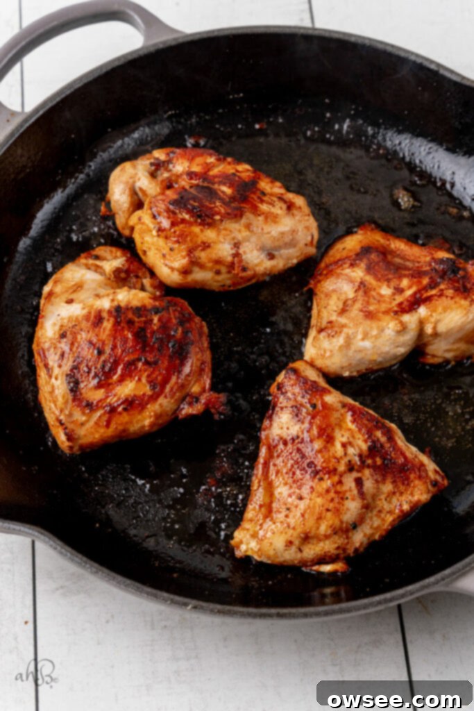 Bold Bang Bang Chicken Bowls 7 The cooked chicken is browned and cooked with oil in the skillet, showing a perfect sear.