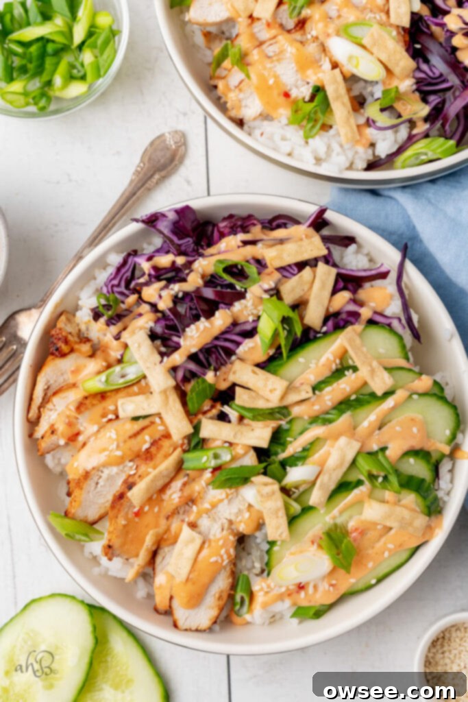 Bold Bang Bang Chicken Bowls 8 The complete bang bang chicken bowl is served with all the toppings in a white bowl, looking delicious and ready to eat.