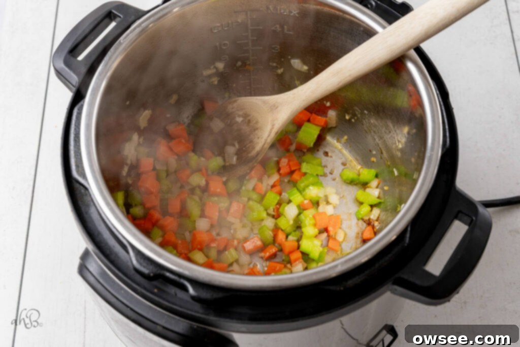 Hearty Instant Pot Minestrone Soup 6 Celery, garlic, carrots, and olive oil are sauteed together in the instant pot and stirred with a wooden spoon.