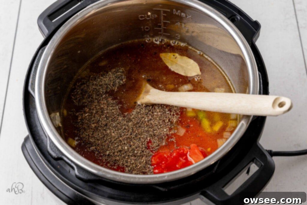 Hearty Instant Pot Minestrone Soup 7 The basil, thyme, marinara sauce, tomatoes, bay leaf, broth, and pasta are added to the instant pot and stirred with a wooden spoon.