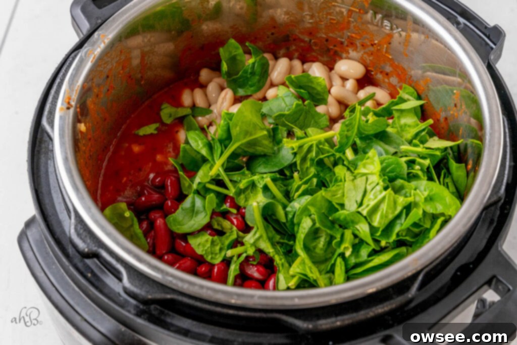 Hearty Instant Pot Minestrone Soup 8 The means and spinach are added to the pot.