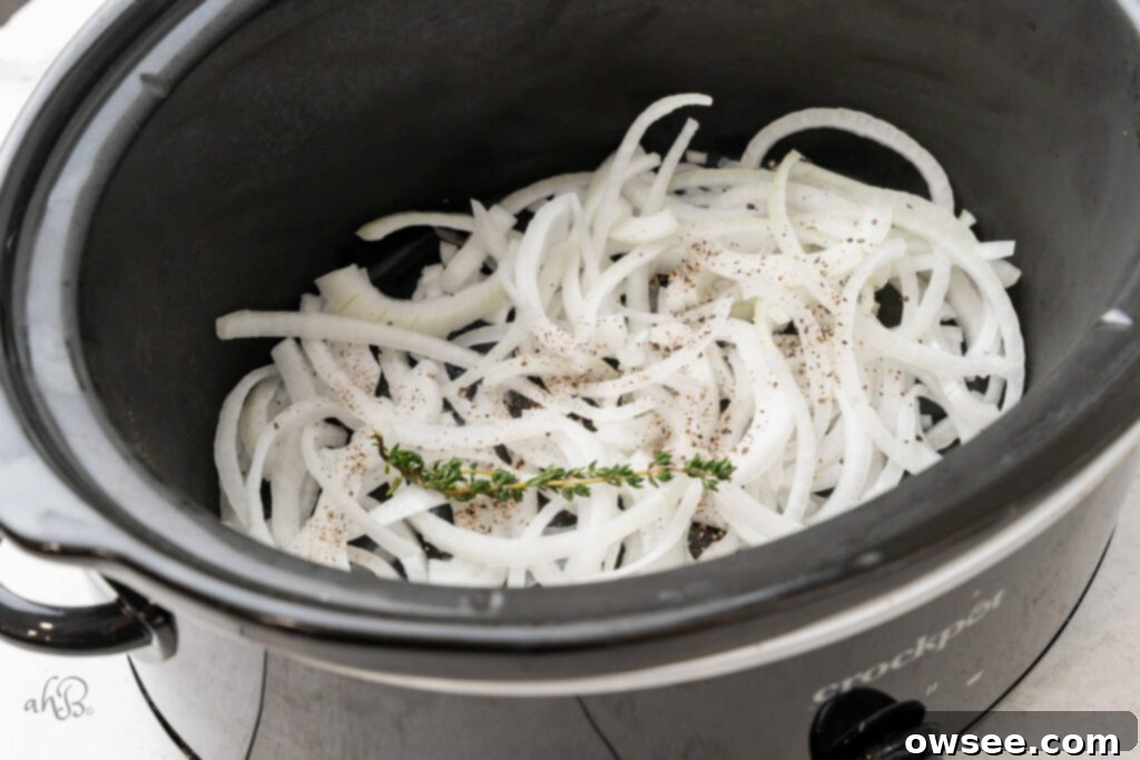 Slow Cooker French Onion Chicken 5 The onions, thyme, and pepper, are added to the bottom of the crockpot.