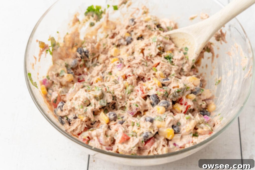 Vibrant Mexican Tuna Medley 8 The ingredients are mixed with a wooden spoon until thoroughly combined.