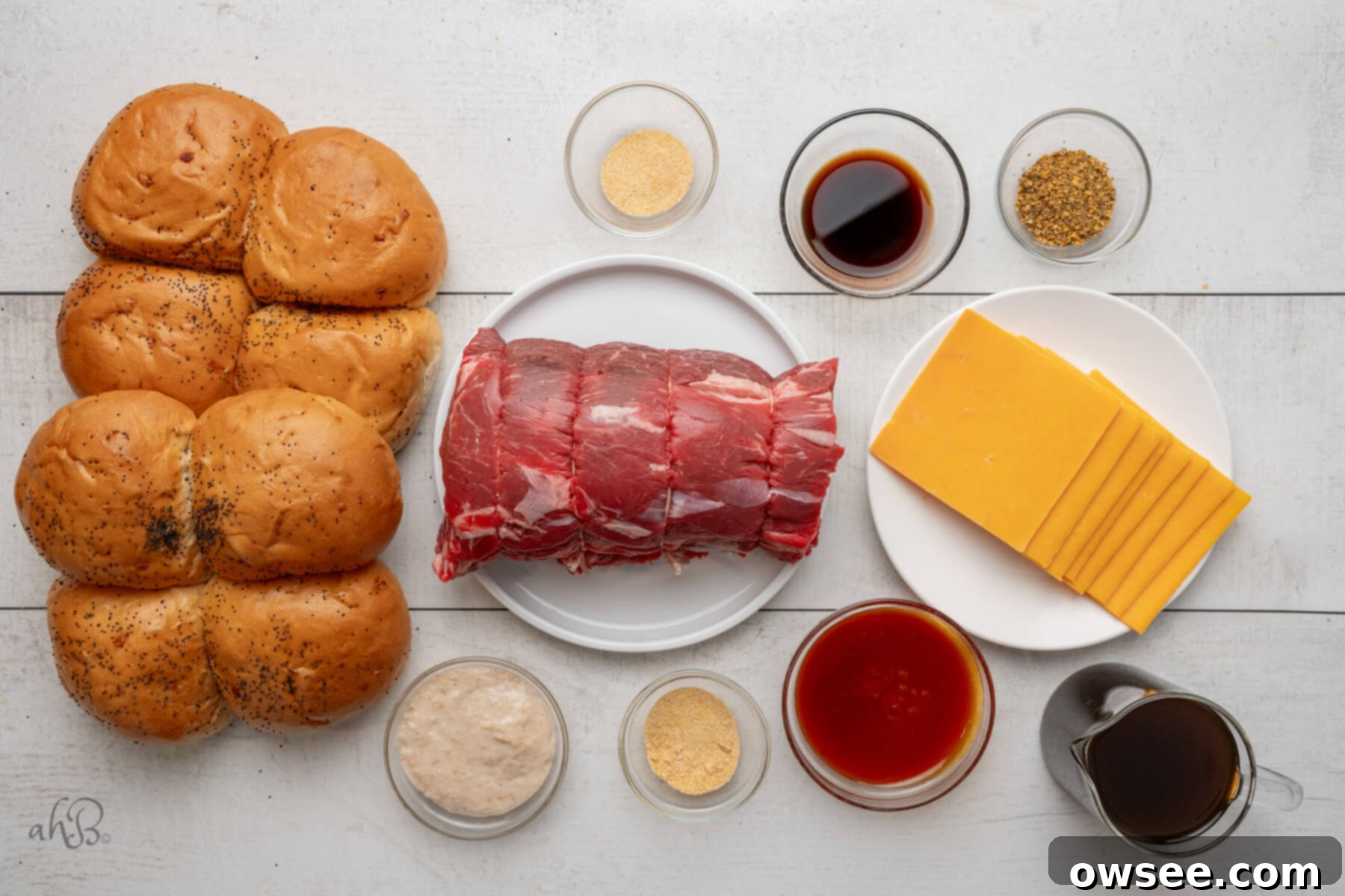 A curated display of all ingredients required for making Crockpot Beef and Cheddar Sandwiches, neatly organized in individual dishes.