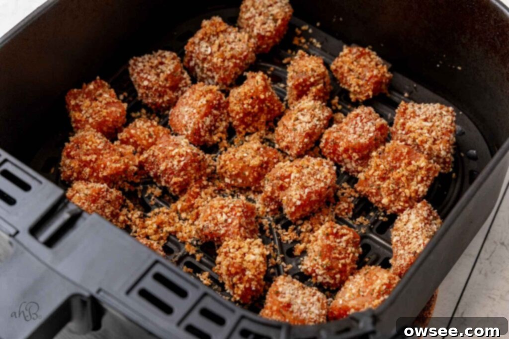 Air Fryer Hot Honey Salmon Bites 8 The breaded salmon bites are carefully arranged in a single layer inside an air fryer basket, ready for cooking.