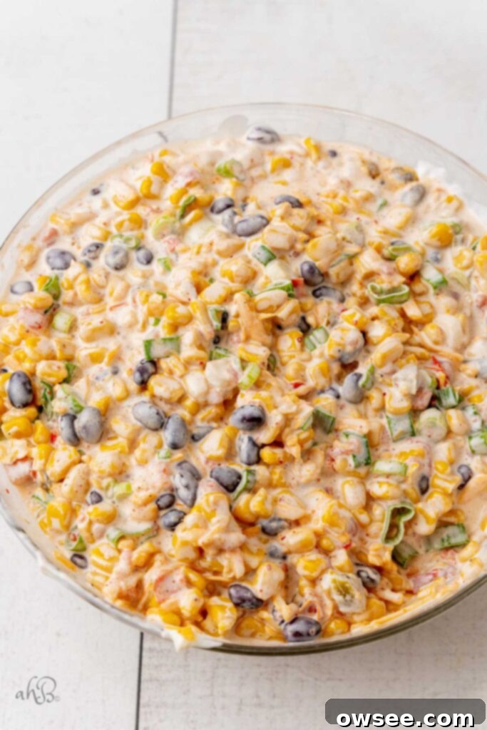 Step 2: The Fiesta Corn Dip is thoroughly mixed in a large bowl, creating a creamy and colorful blend of all the ingredients, ready for chilling.