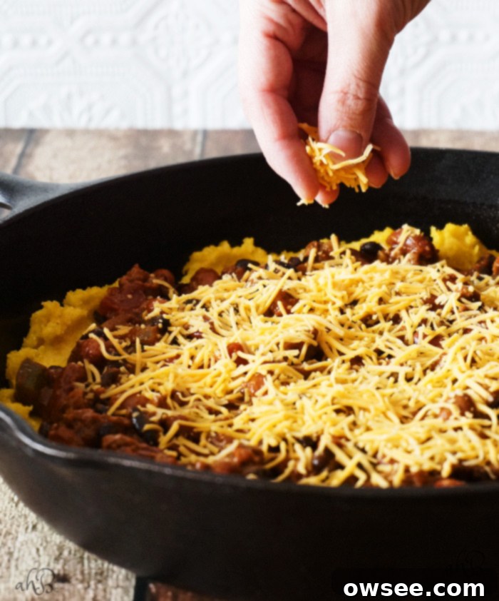 Hearty Chili Cheese Polenta, a satisfying and budget-friendly family meal baked in a cast iron skillet.