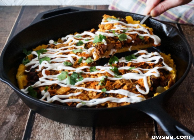 Close-up of Chili Cheese Polenta with crispy edges and a creamy interior, topped with melted cheese and nacho chips, ready to be served.